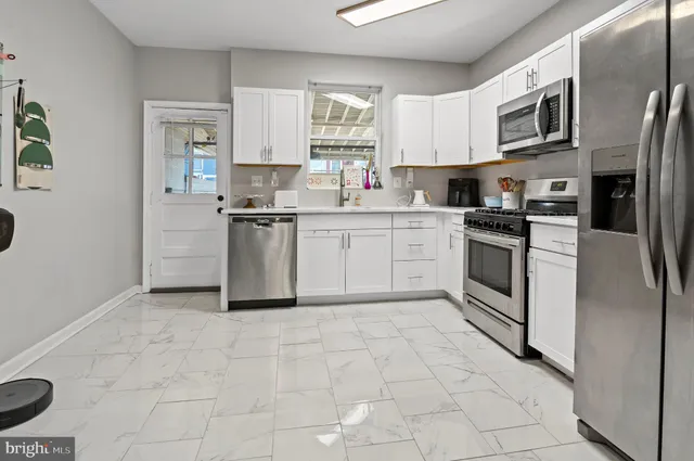 a kitchen with stainless steel appliances granite countertop a stove top oven a sink a refrigerator a microwave and cabinets