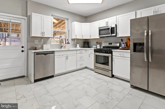 a kitchen with stainless steel appliances granite countertop a stove a sink and a refrigerator