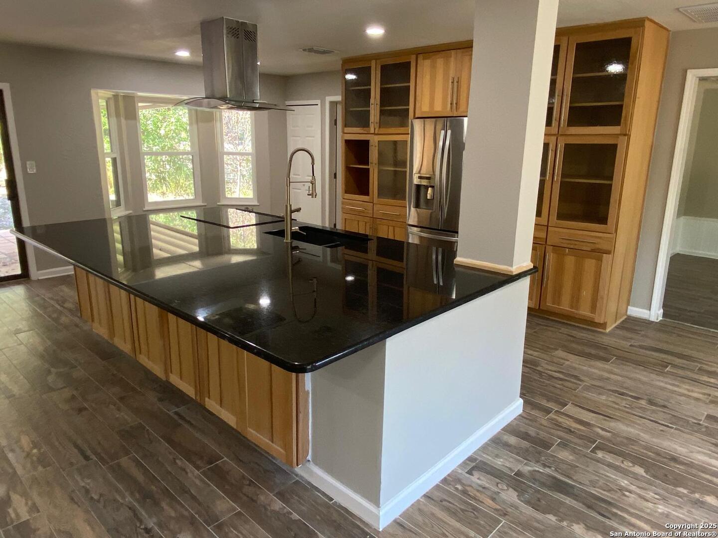 a kitchen with stainless steel appliances granite countertop a refrigerator a sink and a stove