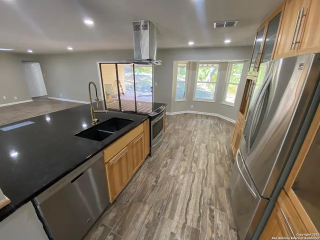 a view of a kitchen with a sink and wooden floor
