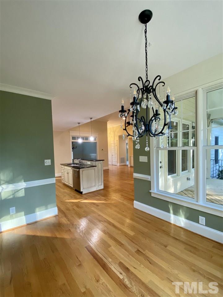 1028 Raleigh, NC 27603 - Photo 17 of 24 a view of a living room with a dining table chairs and a chandelier