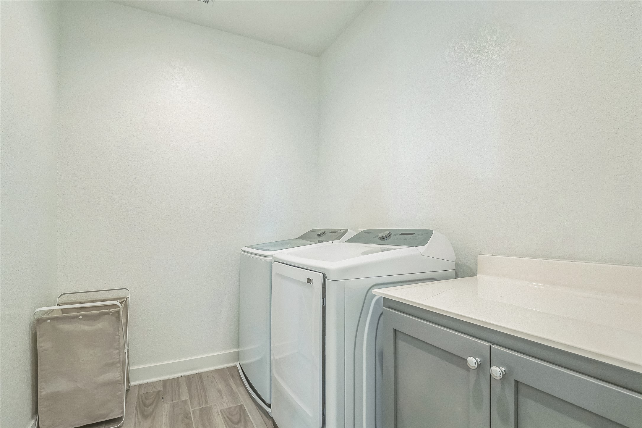 3706 Mesquite Vly Road Georgetown, TX 78628 - Photo 25 of 30 Laundry area featuring cabinet space, washing machine and clothes dryer, light wood-style floors, and baseboards