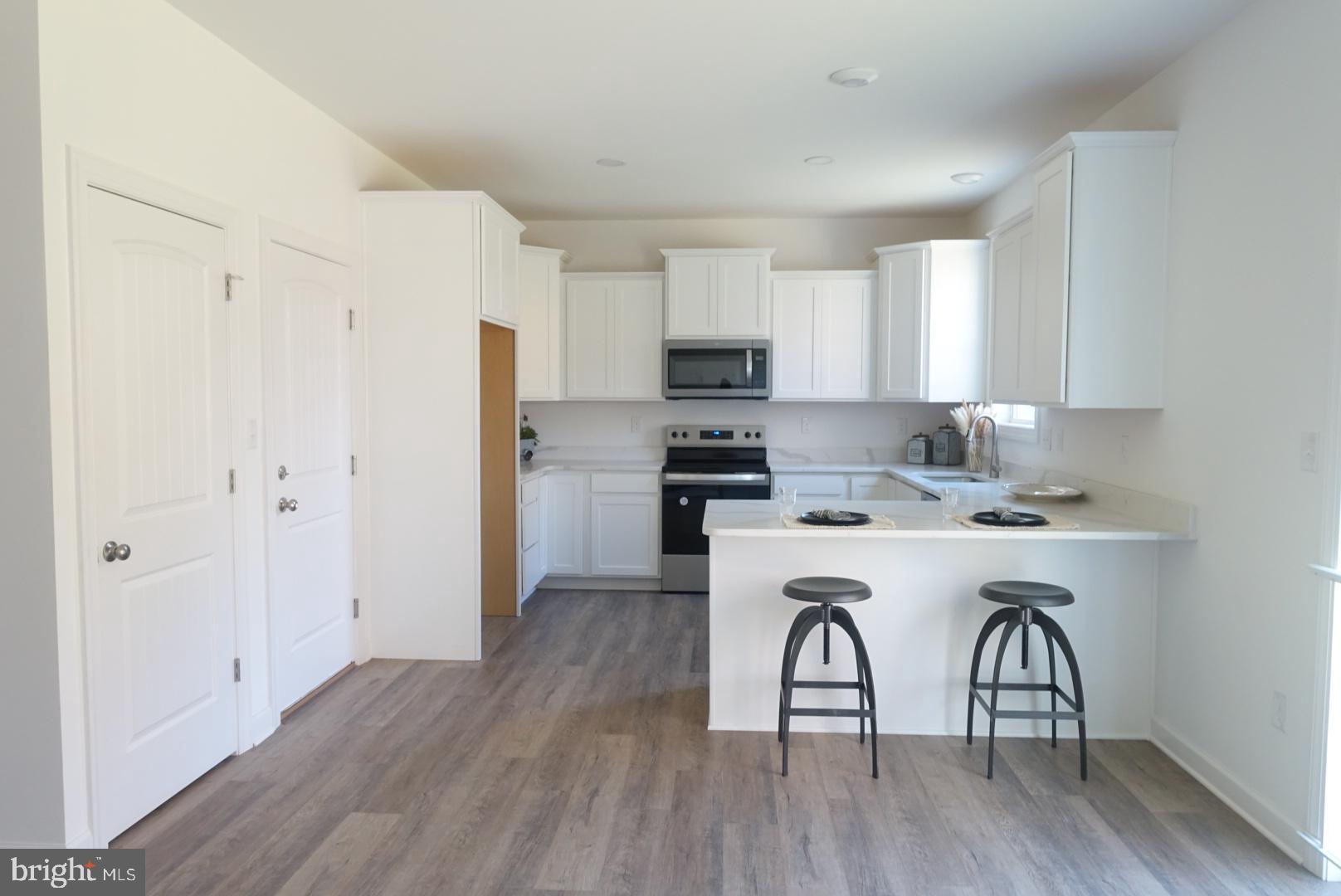 221 Kinneman Road, Unit 28 Abbottstown, PA 17301 - Photo 4 of 26 a kitchen with a refrigerator a sink and a stove top oven