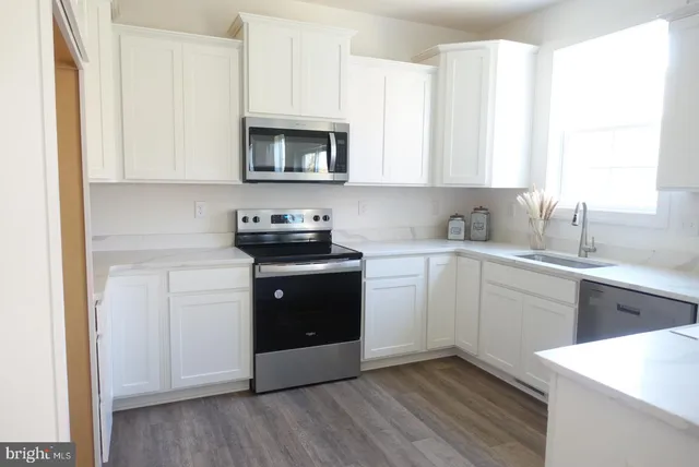 a kitchen with a sink cabinets and a window