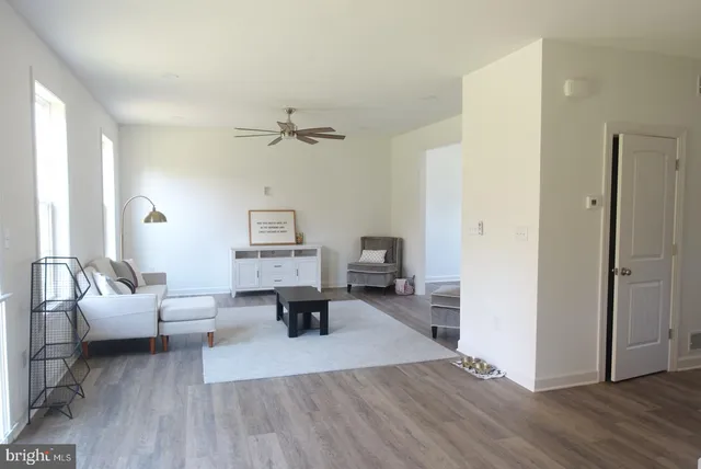 a living room with furniture and a wooden floor