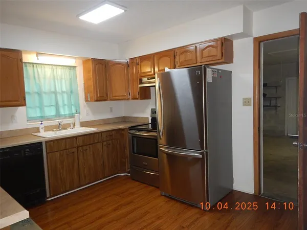 a kitchen with stainless steel appliances granite countertop a refrigerator and a sink