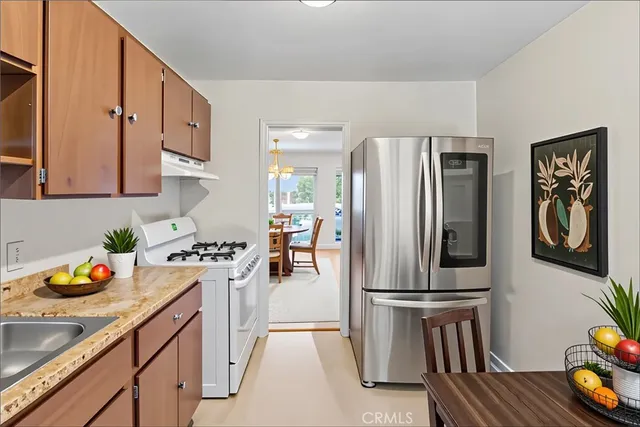 a kitchen with stainless steel appliances granite countertop a refrigerator a stove top oven a sink and dishwasher