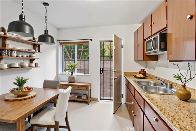 a kitchen with stainless steel appliances granite countertop sink stove top oven and cabinets