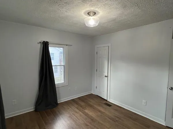 an empty room with wooden floor and closet