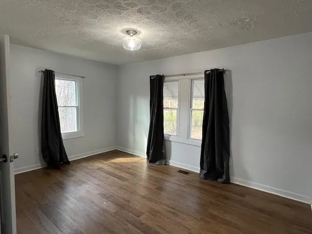 an empty room with wooden floor and a window