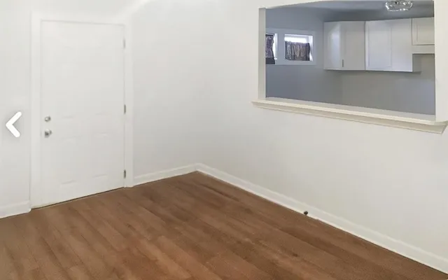 a view of a small space with wooden floor and a window