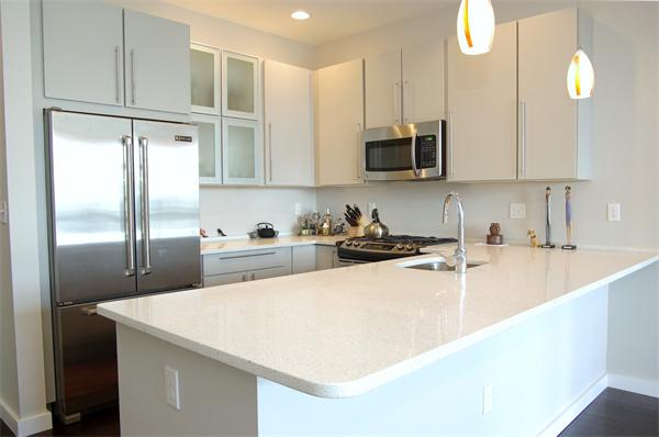 a kitchen with stainless steel appliances granite countertop a sink a refrigerator and a microwave