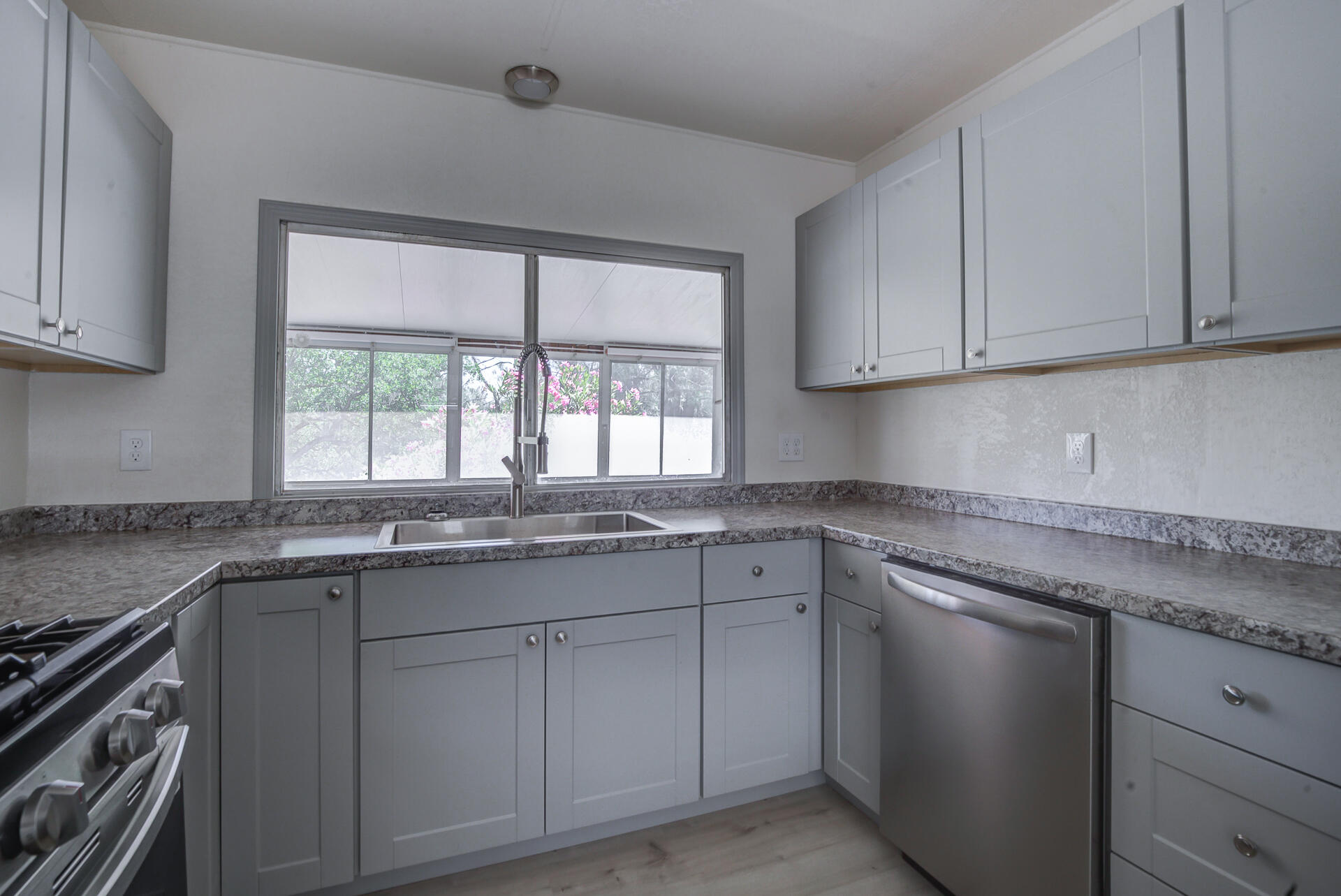 821 St Marks Street, Unit 1 Redding, CA 96003 - Photo 11 of 26 a kitchen with granite countertop stainless steel appliances white cabinets sink and window