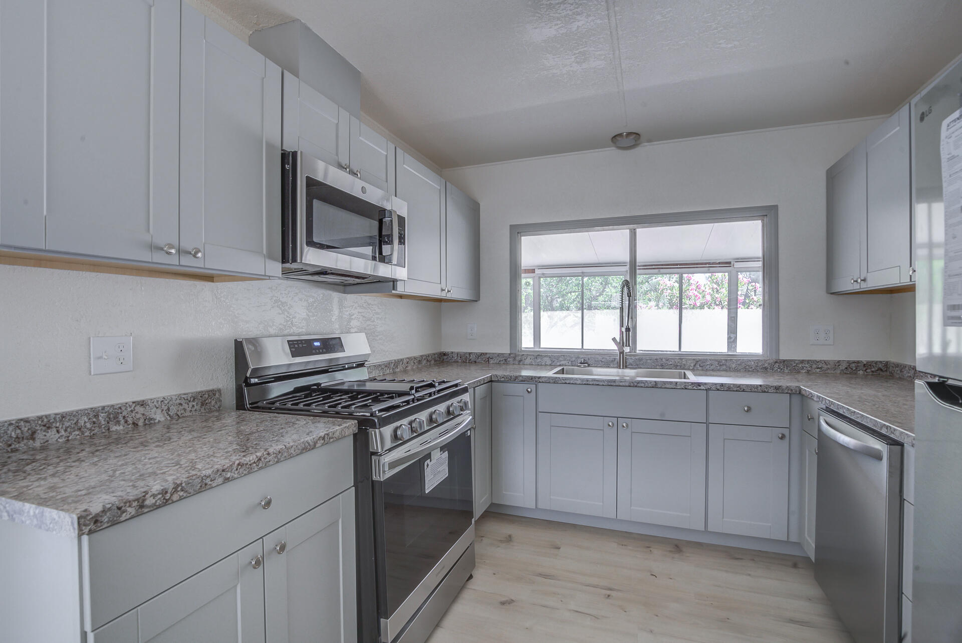 821 St Marks Street, Unit 1 Redding, CA 96003 - Photo 9 of 26 a kitchen with stainless steel appliances granite countertop white cabinets granite counter tops and a window