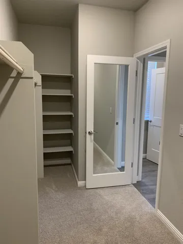a view of a hallway and a bathroom with mirror