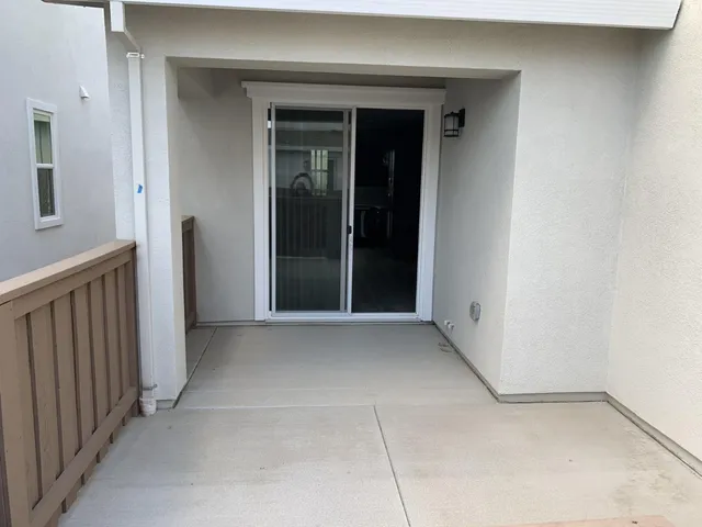 en empty room with windows and chandelier fan