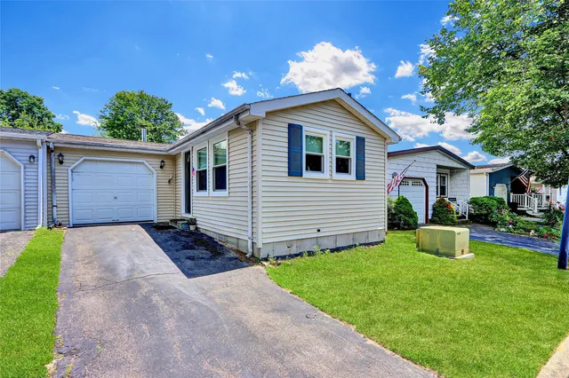 a front view of house with yard and garage