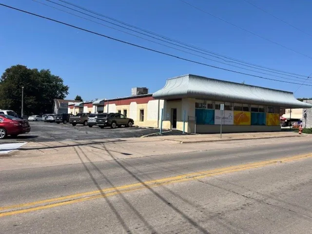 a view of a building with car parked on the road
