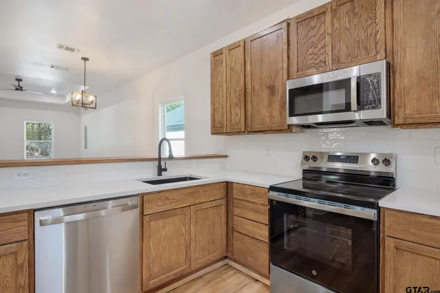 a kitchen with stainless steel appliances a stove a microwave sink and cabinets