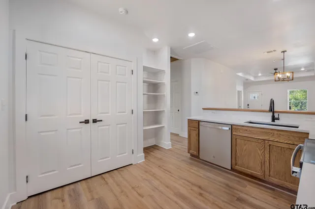 a view of a kitchen with a sink and dishwasher refrigerator with wooden floor