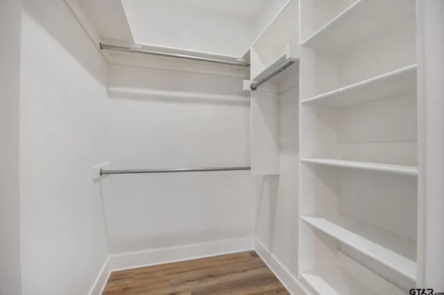 a view of walk in closet with wooden floor
