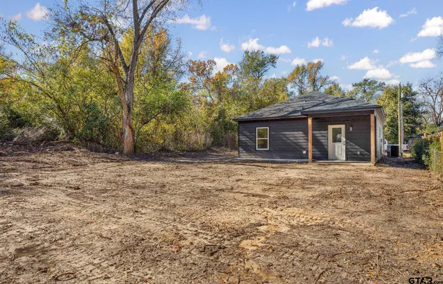 a front view of a house with a garden and trees