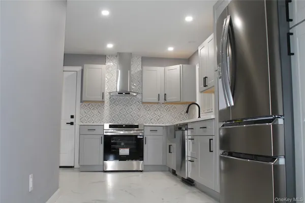 a kitchen with stainless steel appliances granite countertop a stove a refrigerator and a sink