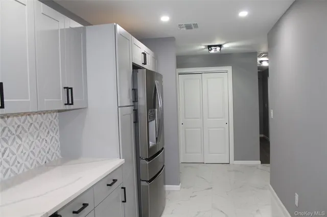 a view of cabinets with stainless steel appliances wooden floor and a window