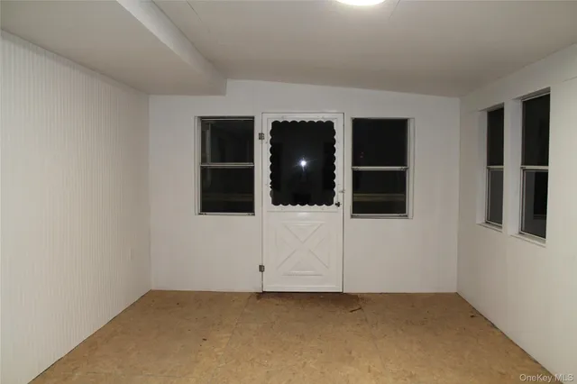 an empty room with windows and television