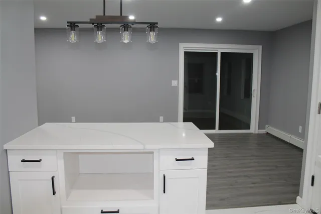 an empty room with wooden floor and entrance