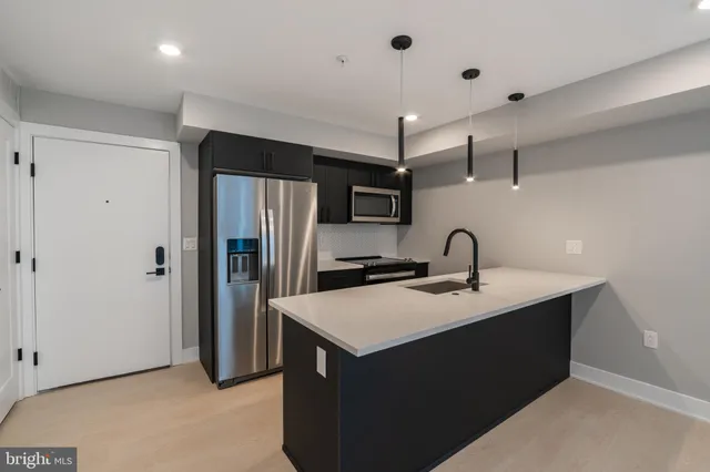 a kitchen with stainless steel appliances a sink stove and refrigerator