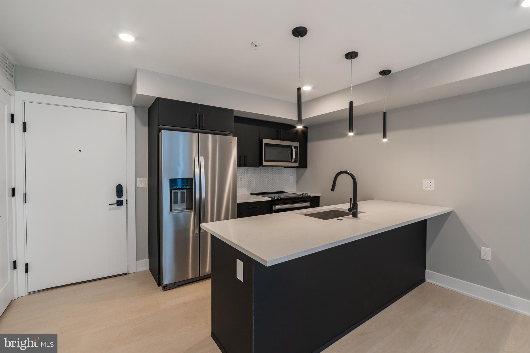 6604 Ridge Avenue, Unit 302 Philadelphia, PA 19128 - Photo 1 of 11 a kitchen with stainless steel appliances a sink stove and refrigerator