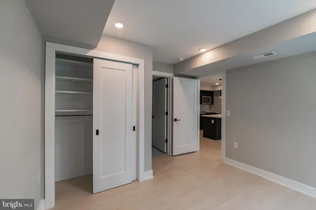a view of hallway with closet and wooden shelves