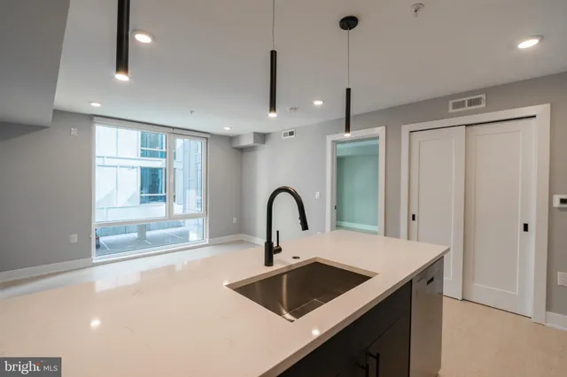 a kitchen with a sink a counter and a dining table
