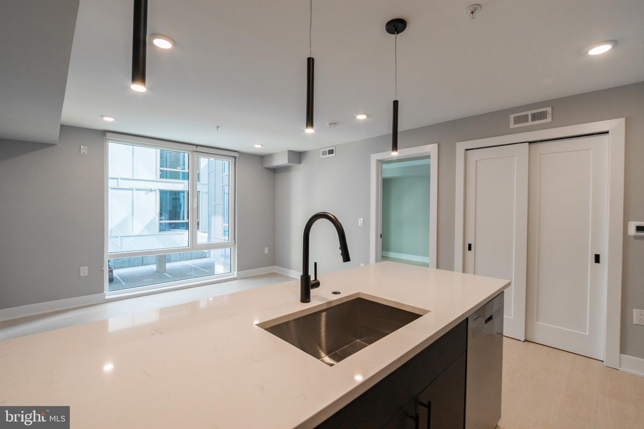6604 Ridge Avenue, Unit 302 Philadelphia, PA 19128 - Photo 3 of 11 a kitchen with a sink a counter and a dining table
