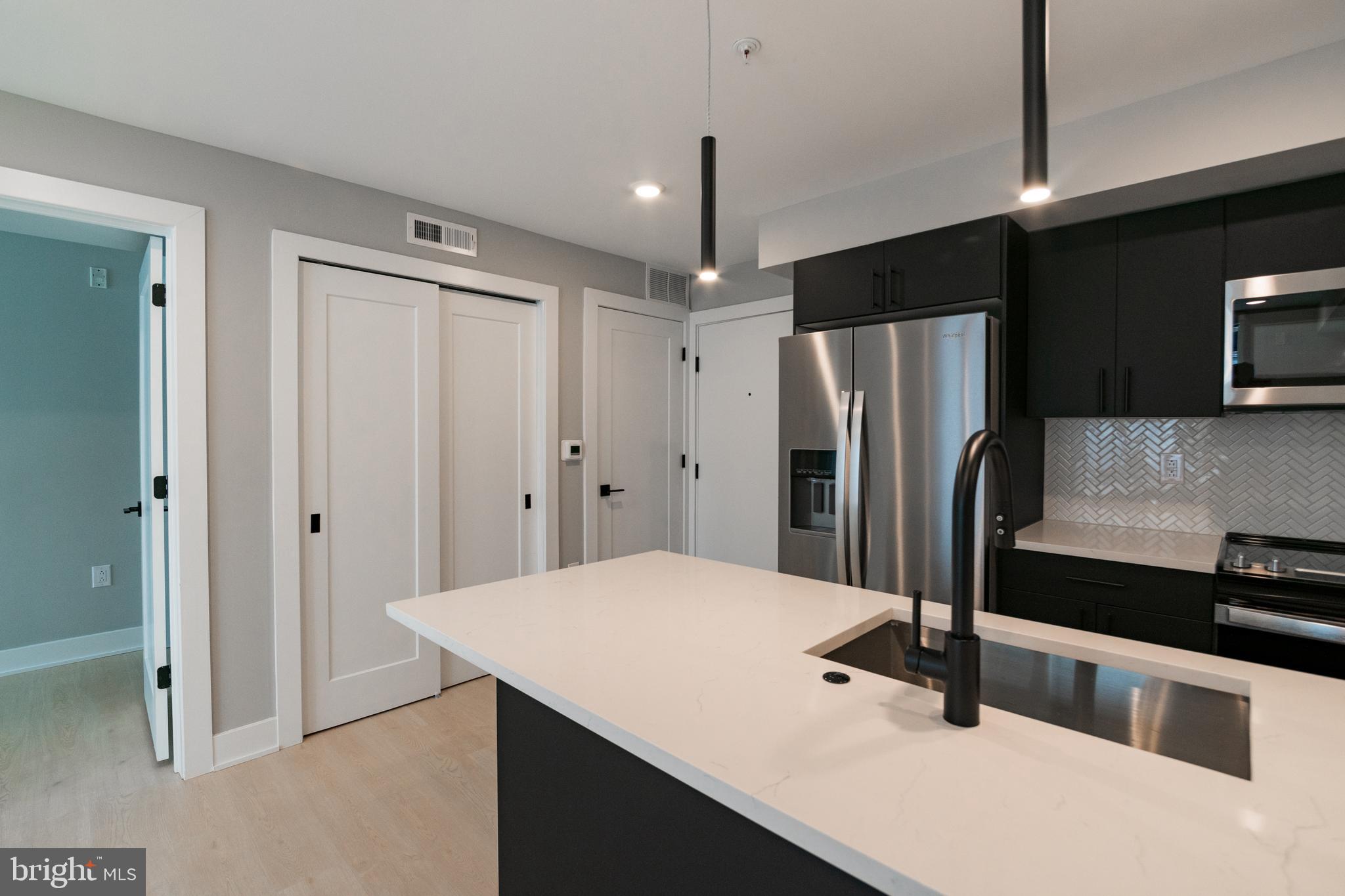 6604 Ridge Avenue, Unit 302 Philadelphia, PA 19128 - Photo 5 of 11 a kitchen with stainless steel appliances a refrigerator and a sink
