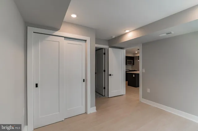 a view of hallway with closet and wooden shelves