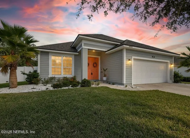 a front view of a house with a garden and yard