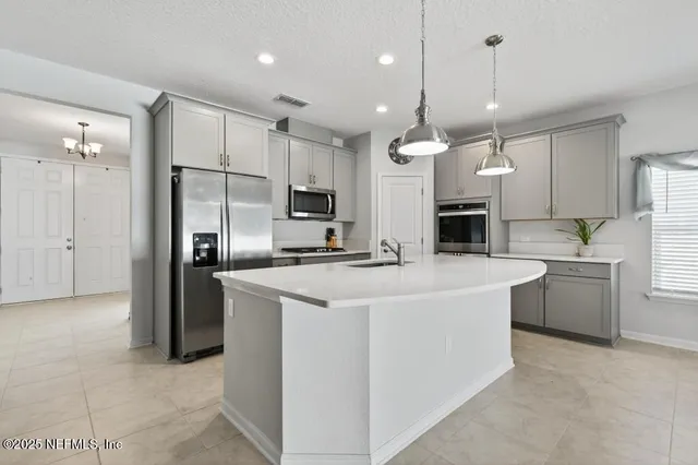 a kitchen with kitchen island a sink stove and refrigerator