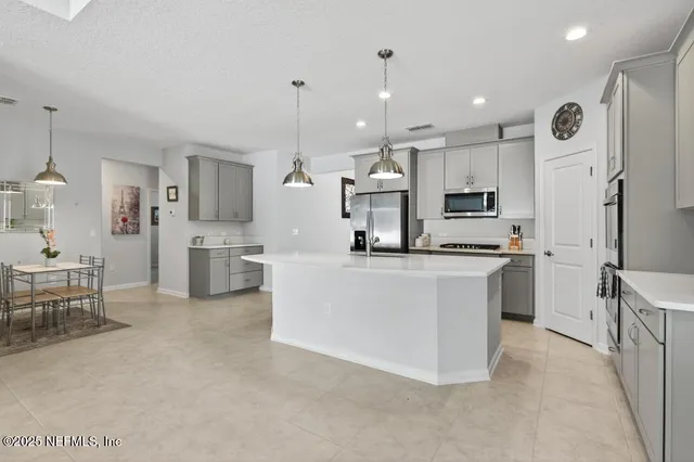 a living room with furniture a large window and a chandelier