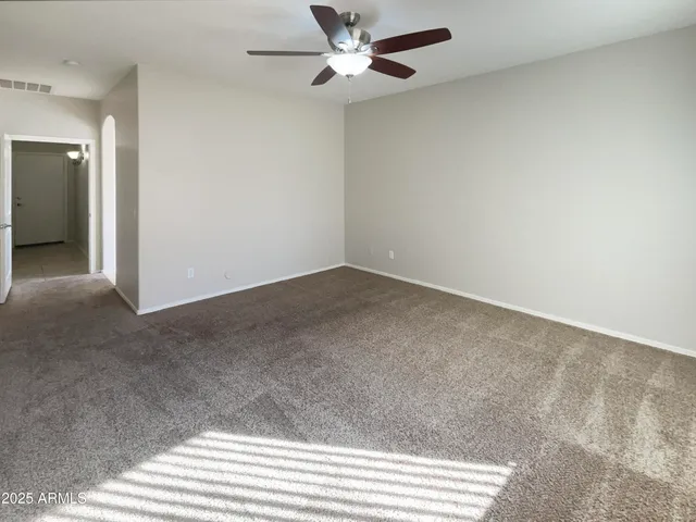 an empty room with closet and a ceiling fan