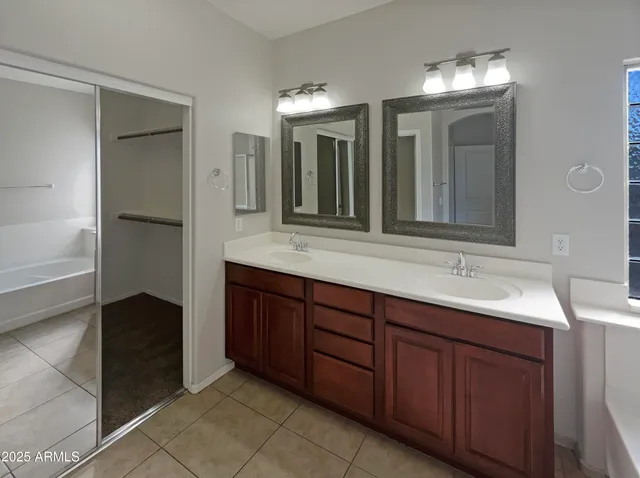 a bathroom with a double vanity sink and a mirror