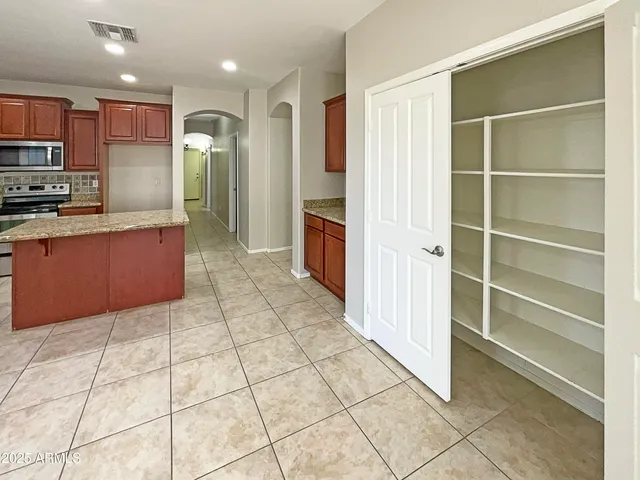 a kitchen with stainless steel appliances granite countertop a refrigerator and a stove top oven