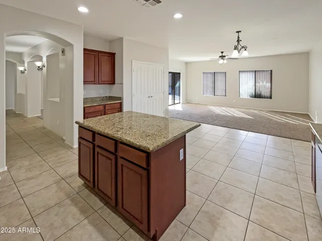 an empty room with a fan & a window