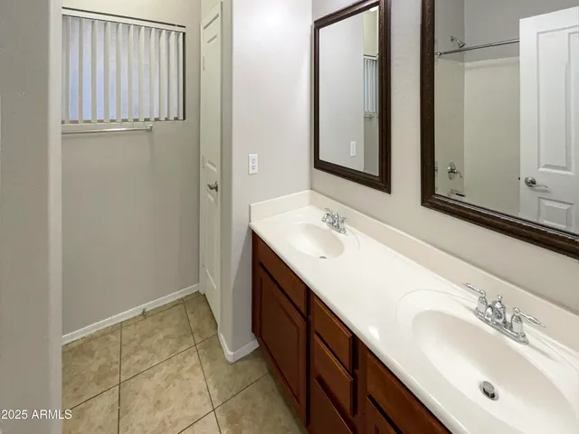 a bathroom with a double vanity sink and a mirror
