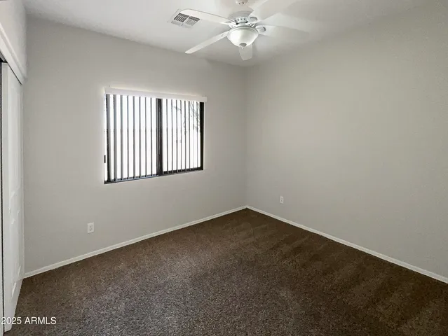a view of an empty room with a ceiling fan