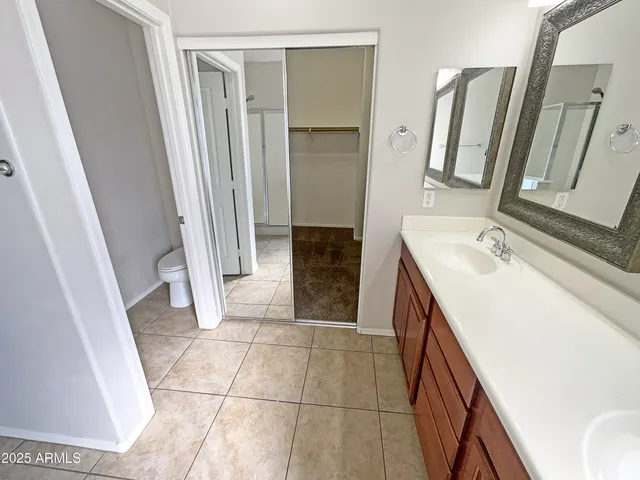 a bathroom with a sink a toilet and a mirror
