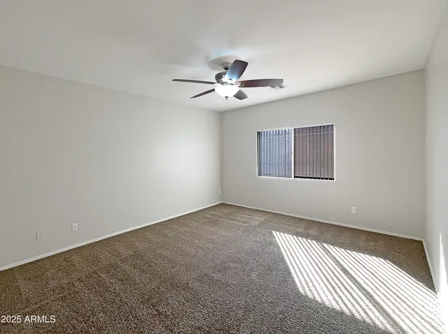 a view of an empty room with a ceiling fan
