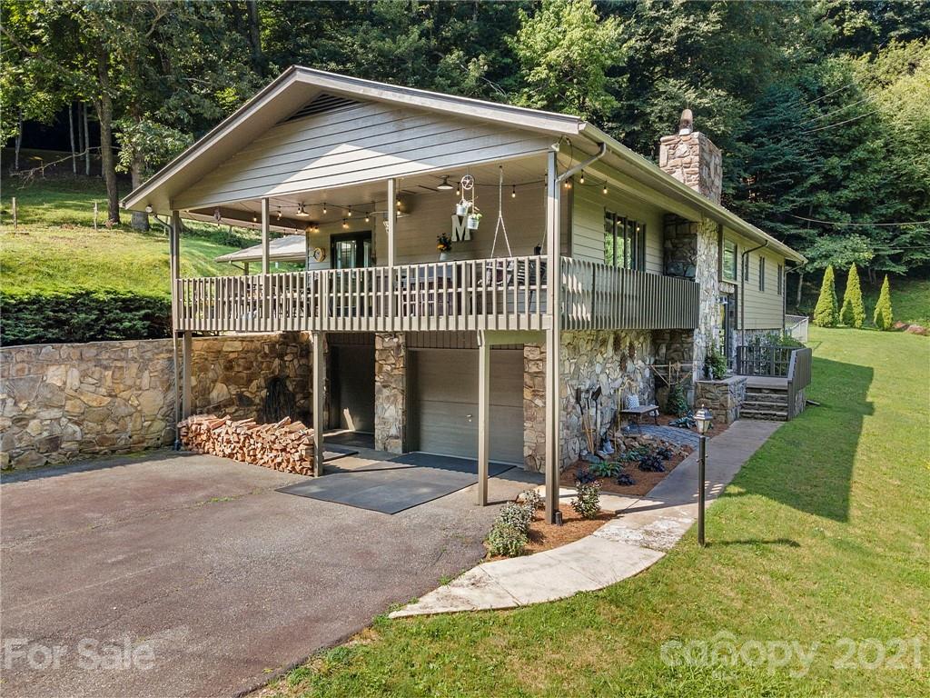 1004 Lickstone Road Waynesville, NC 28786 - Photo 1 of 39 a front view of a house with porch and garden