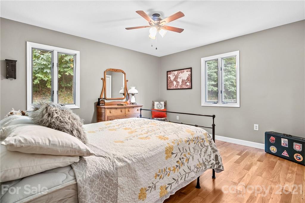 1004 Lickstone Road Waynesville, NC 28786 - Photo 21 of 39 a bedroom with a bed and a chandelier